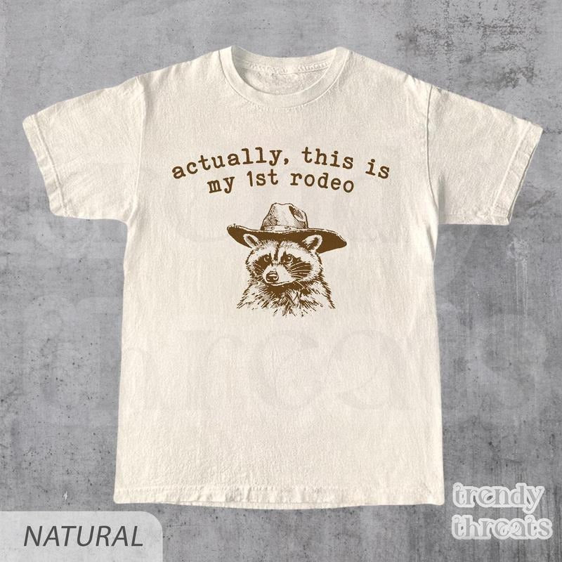 Actually, This Is My First Rodeo T-Shirt | Funny Western Graphic Tee | Raccoon Quote | Retro Shirt Unique Gift Idea | Unisex Shirt